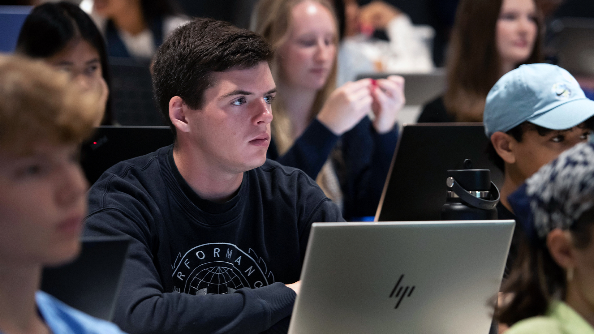 Drake International Business students, in class with their laptops, listen intently to a lecture