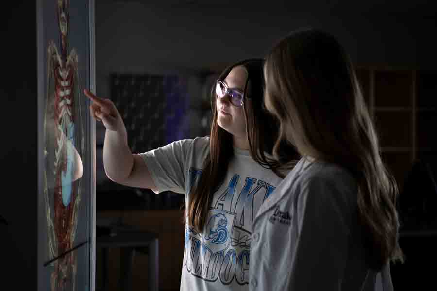 In a STEM Complex lab, two Drake students examine the body with an anatomage table for a Kinesiology assignment