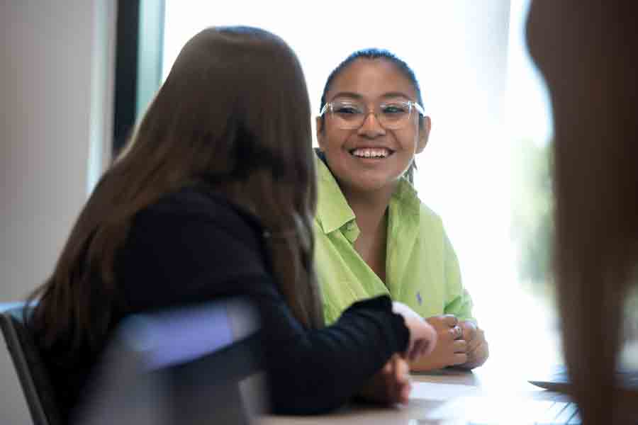 Two students in Drake's Latin American Studies program smile at each other while collaborating on research