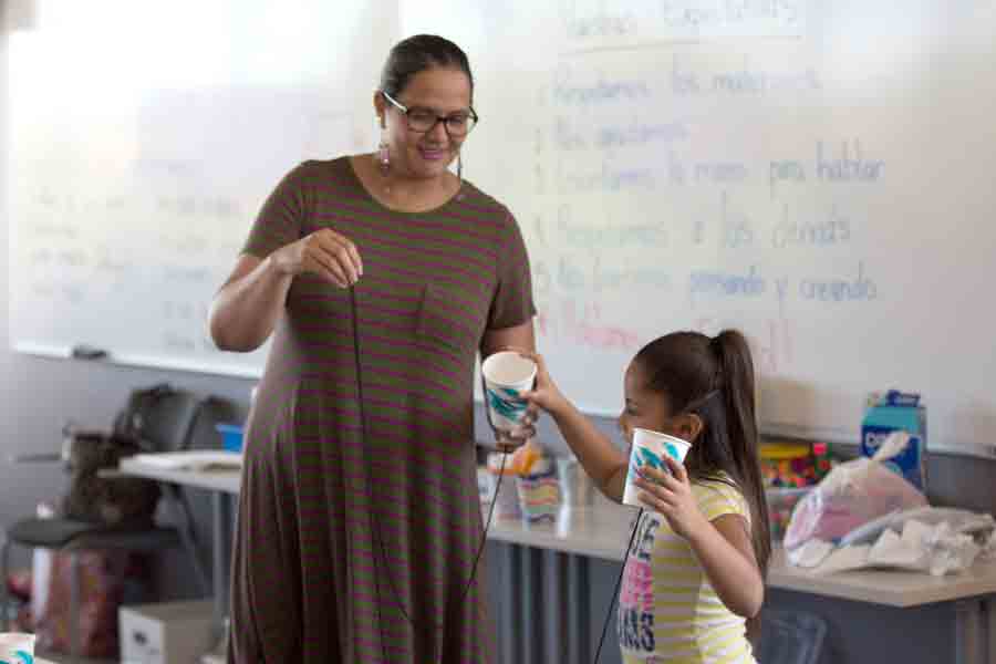 During a service learning assignment, a student in Drake's Latin American Studies program creates a cup-and-string telephone with an elementary-age student