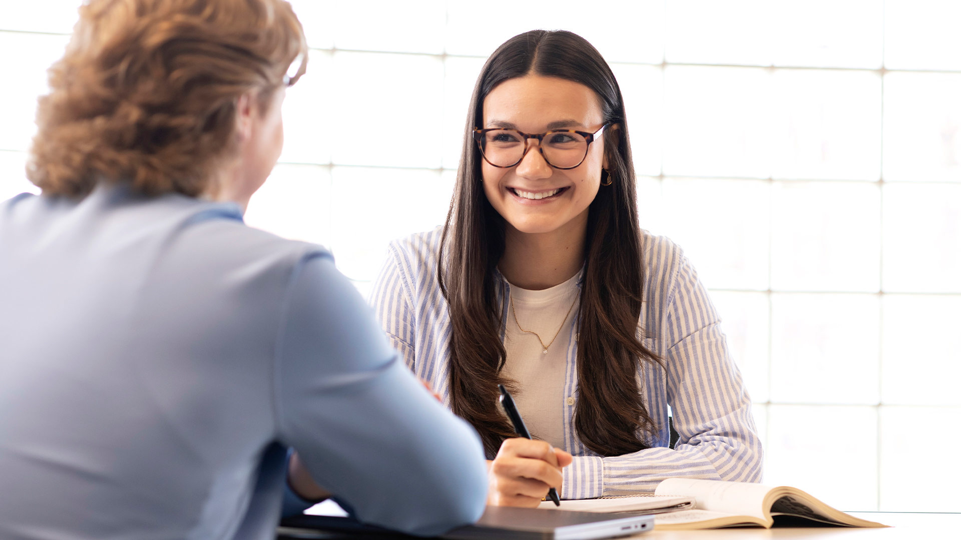 Two Drake Law and Business minors smile while reviewing course materials