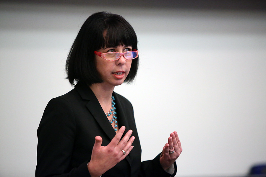 A Drake Marketing major in glasses and a blazer presents their capstone to an audience