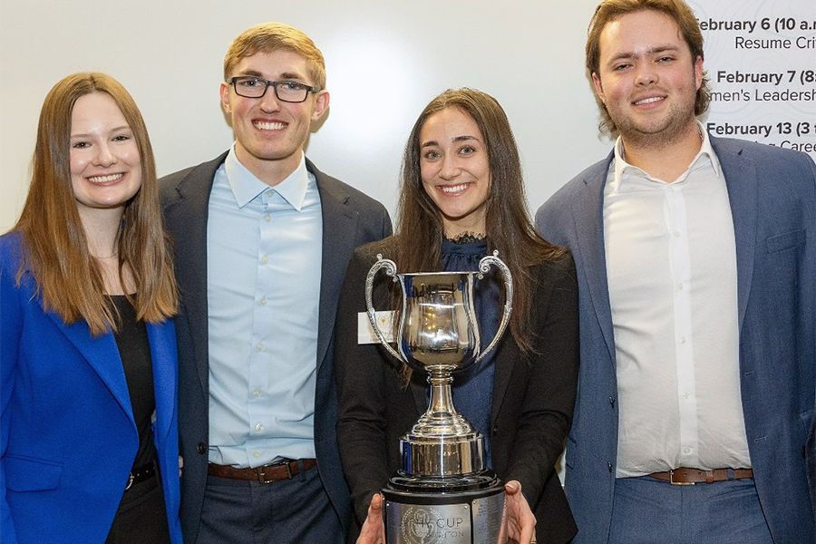 Four Drake Marketing majors hold the Murphy Cup after winning the competition