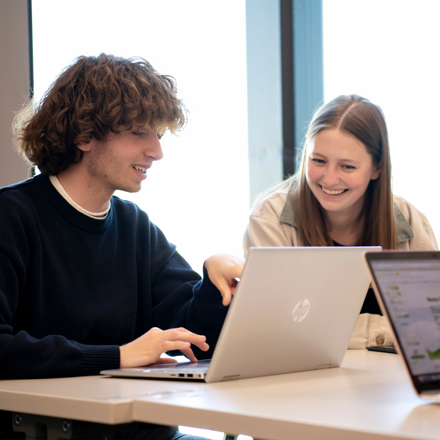 Two Drake Mathematics students work on an assignment, with one pointing to a laptop