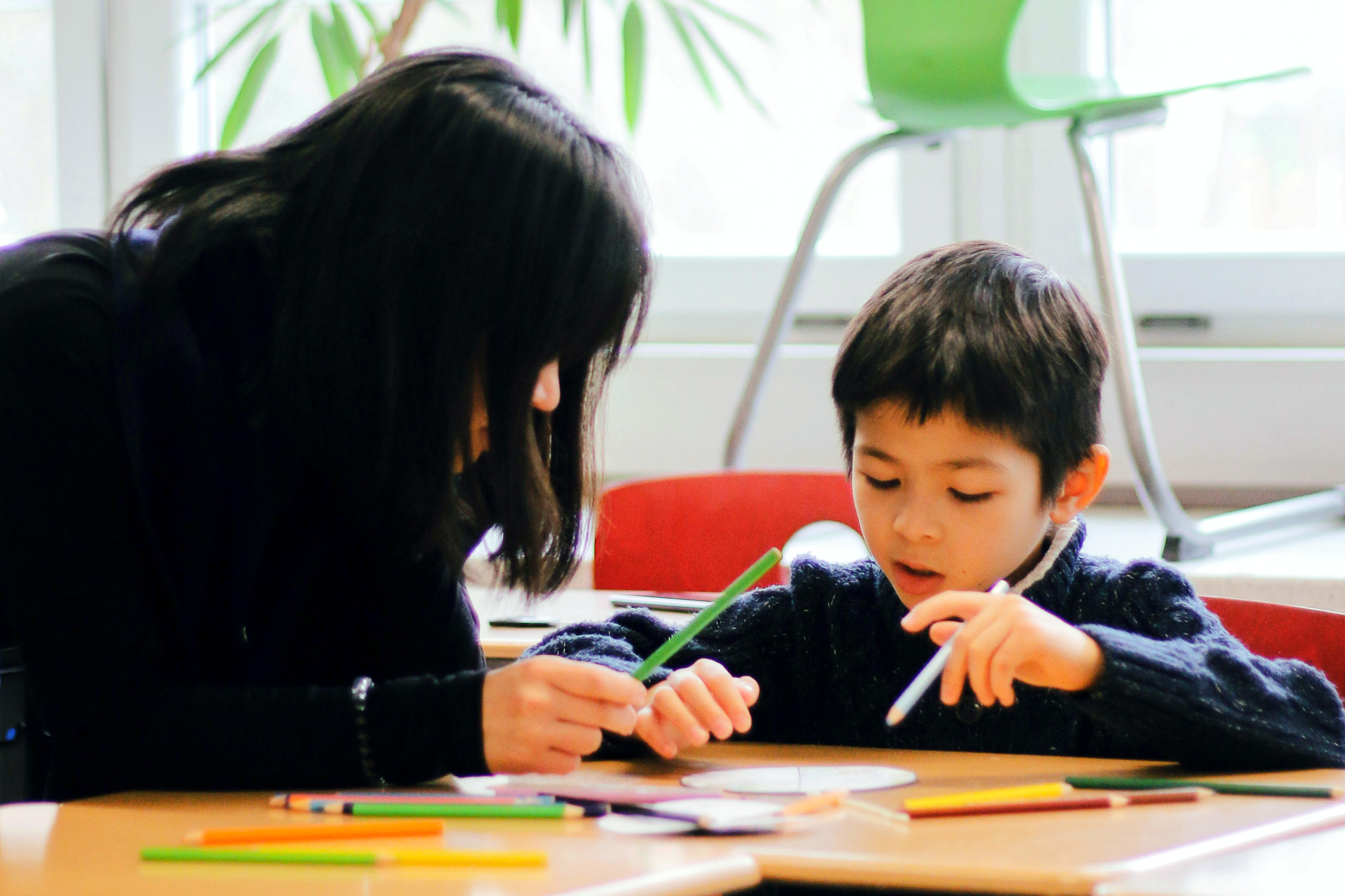 A student in Drake's Mathematics for Secondary Education program works one-on-one with a preschool-age student to solve a problem