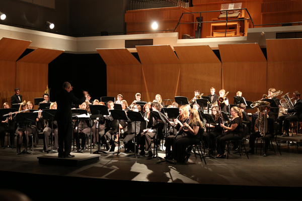 A conductor leads a practice session for one of Drake's winds and brass ensembles