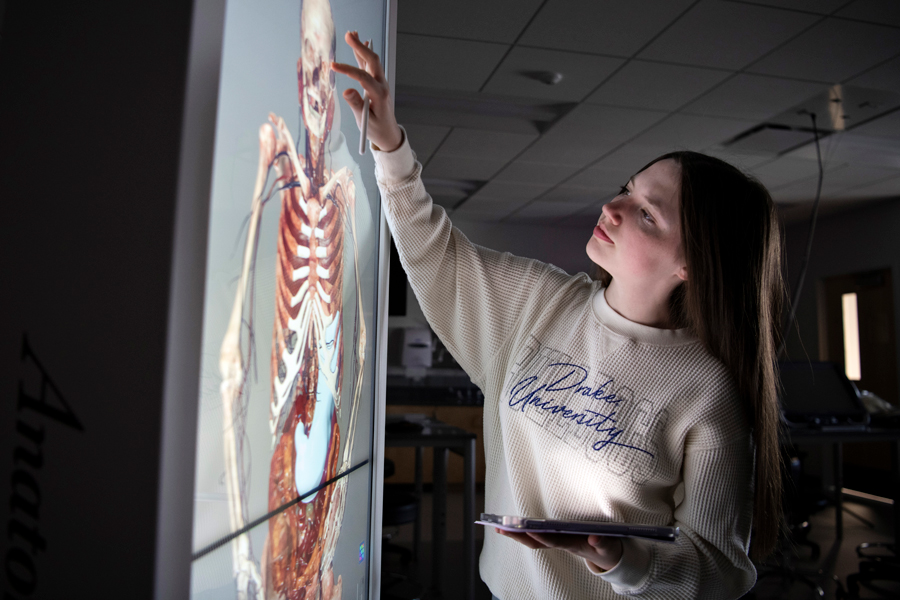 In a dark lab, a Neuroscience student at Drake zooms in on the human body with an anatomage table