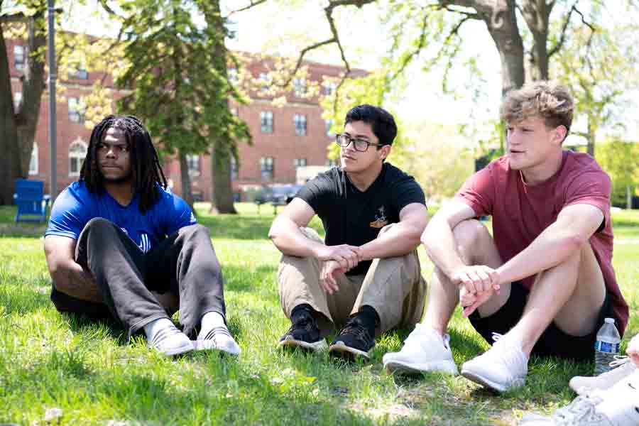 Drake Philosophy students hold a club meeting outdoors on the grass