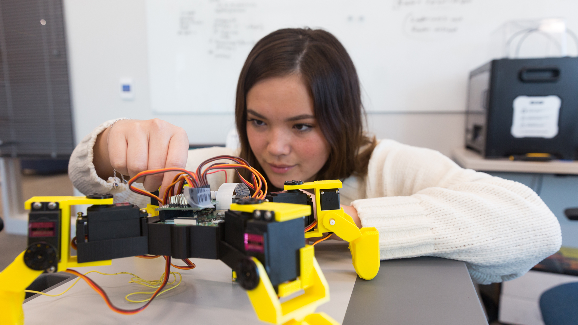 In a campus laboratory, a Physics student at Drake tests a circuit for a robot