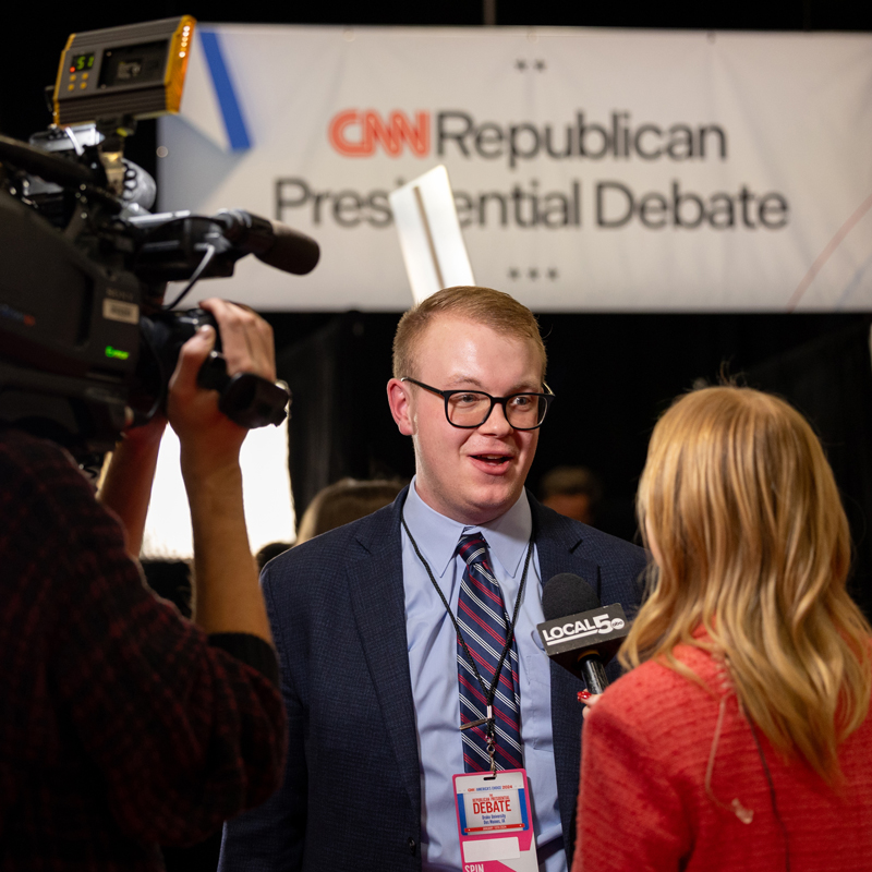A Drake Politics students with a press pass speaks to reporters during the Republican presidential debate