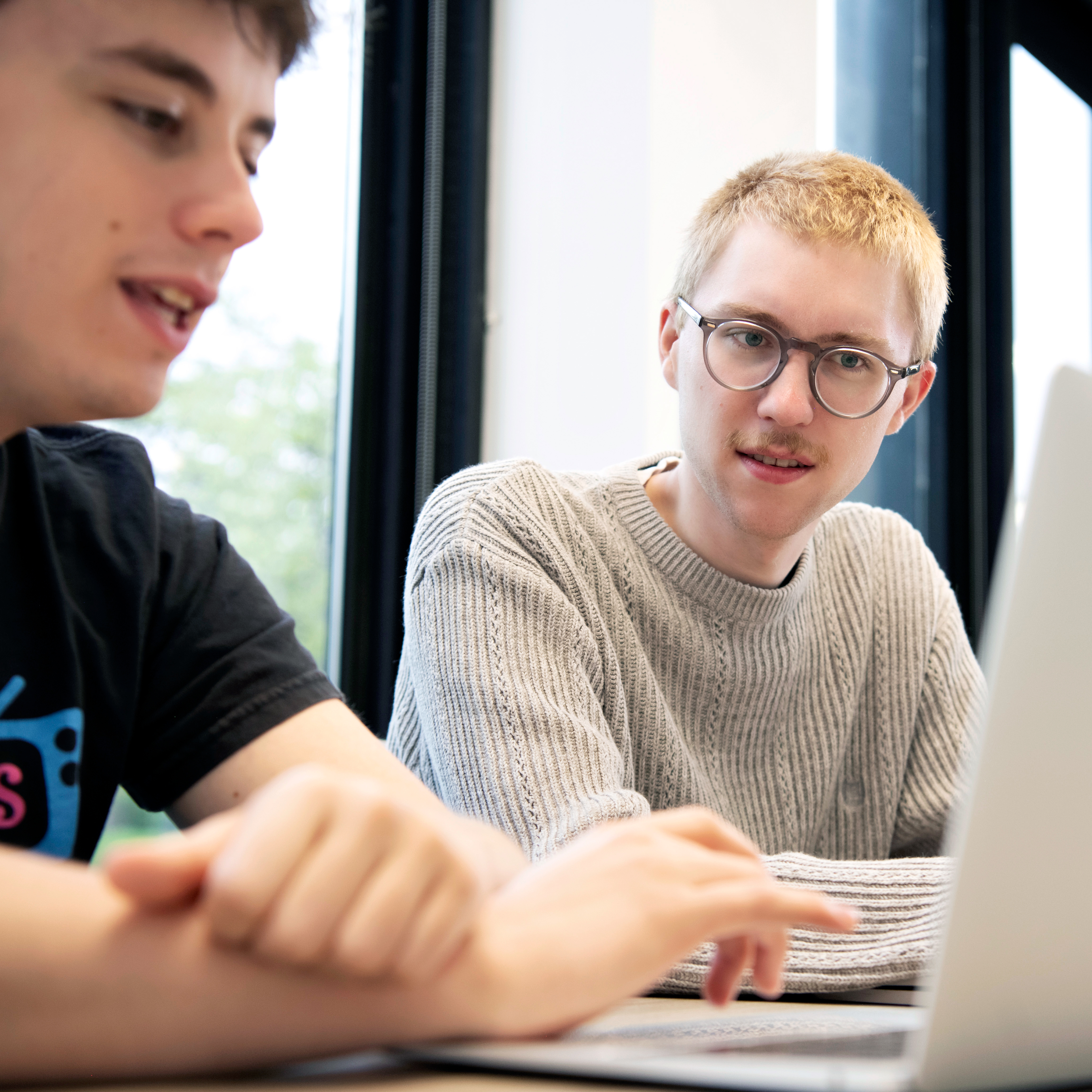 Two Drake Pre-Engineering students review assignment information from a laptop