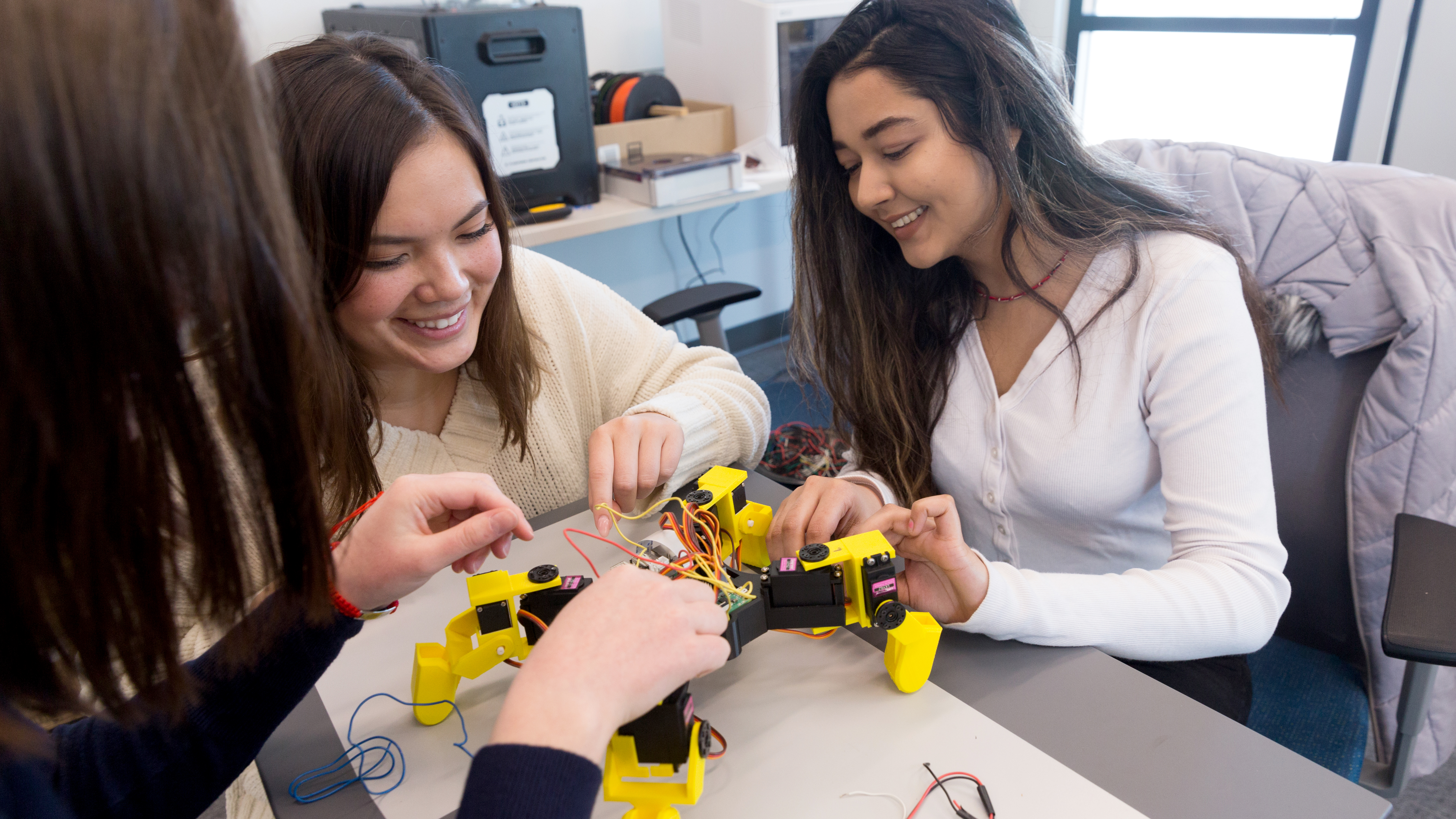 Three students in Drake's Pre-Engineering program construct a robot