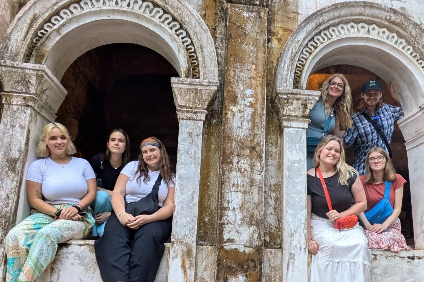 Drake students relax around the arches of a historic building during a study abroad trip