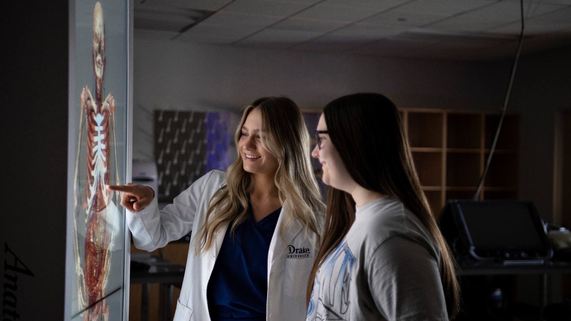 Offering an overview of the human body to a Drake Pre-Med student, a faculty member traces the skeletal and muscular systems from an anatomage table