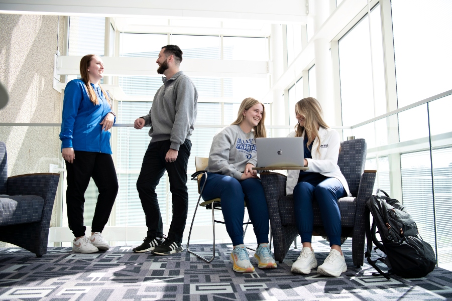 A group of Pre-Med students meet up in the corner of a sunlit common area on Drake's campus