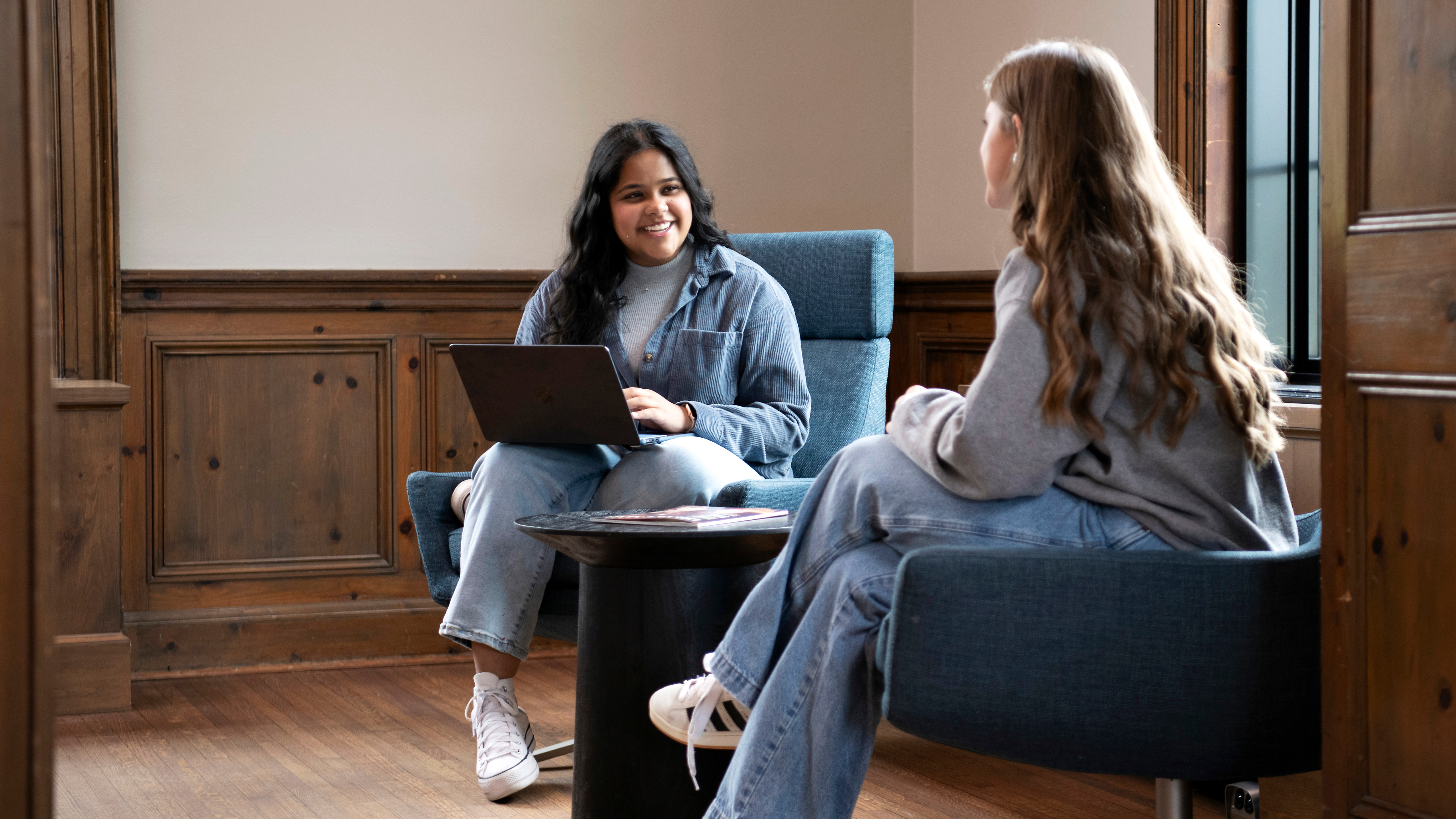 Two Drake Psychology majors engage in a study session on a couch in a common area