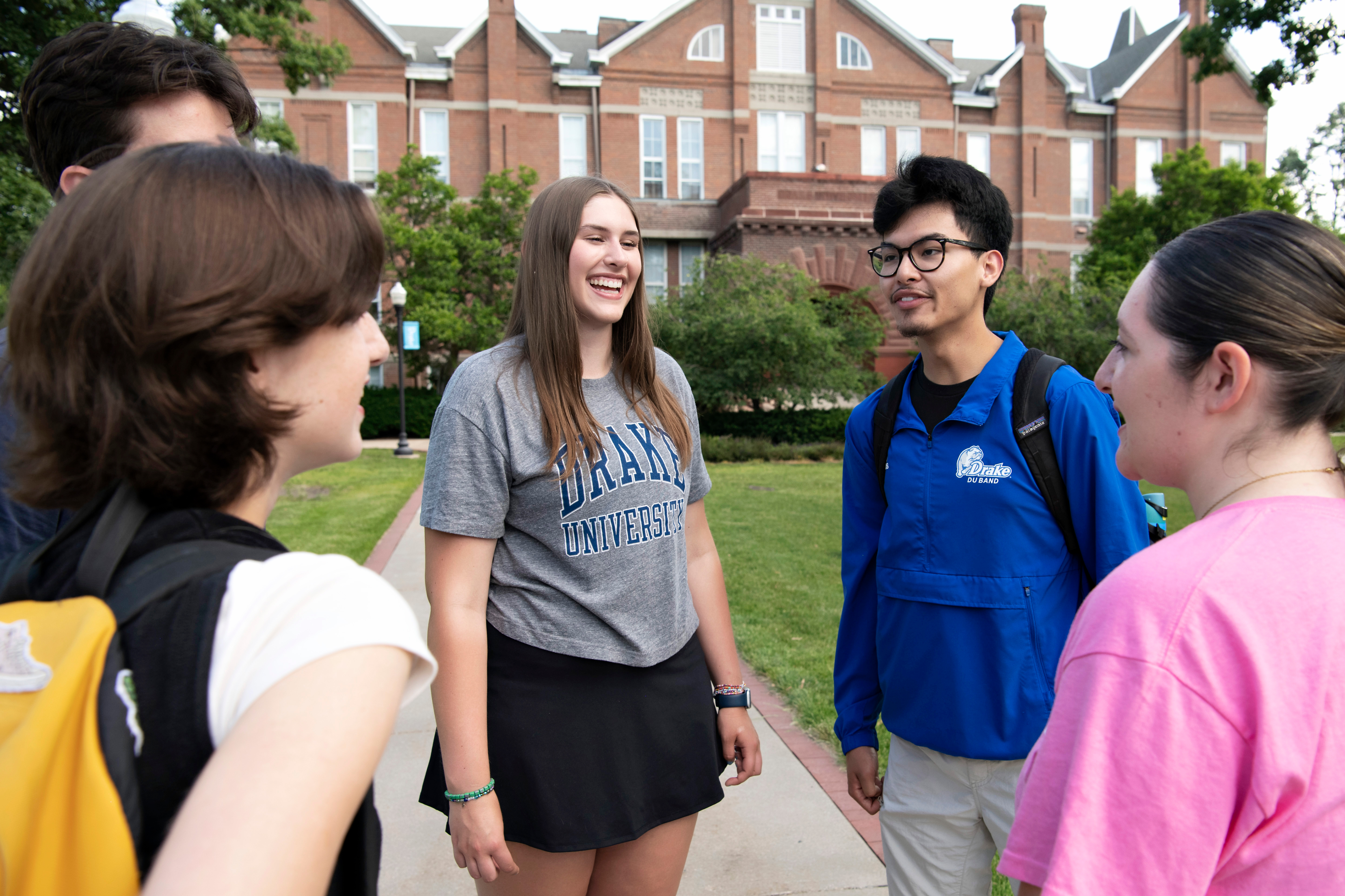 A group of Psychology students stand in a circle outdoors during a club-sponsored event