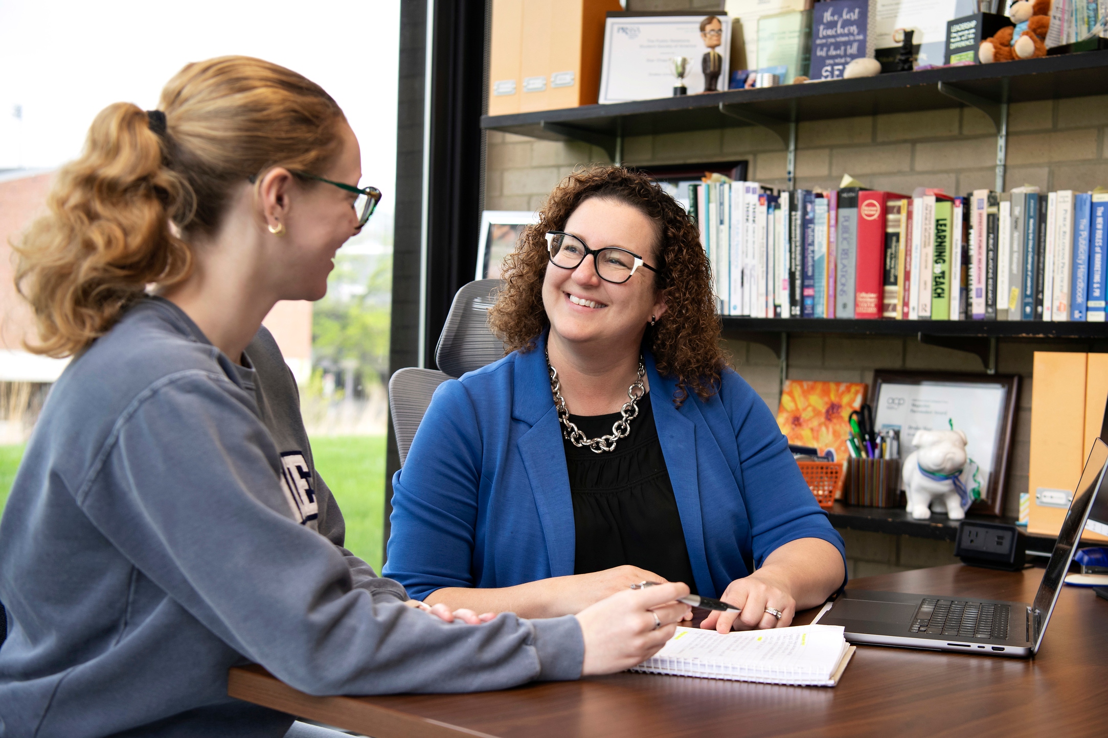 A Drake Public Relations Major smiles during a meeting with a career advisor in a well-lit office