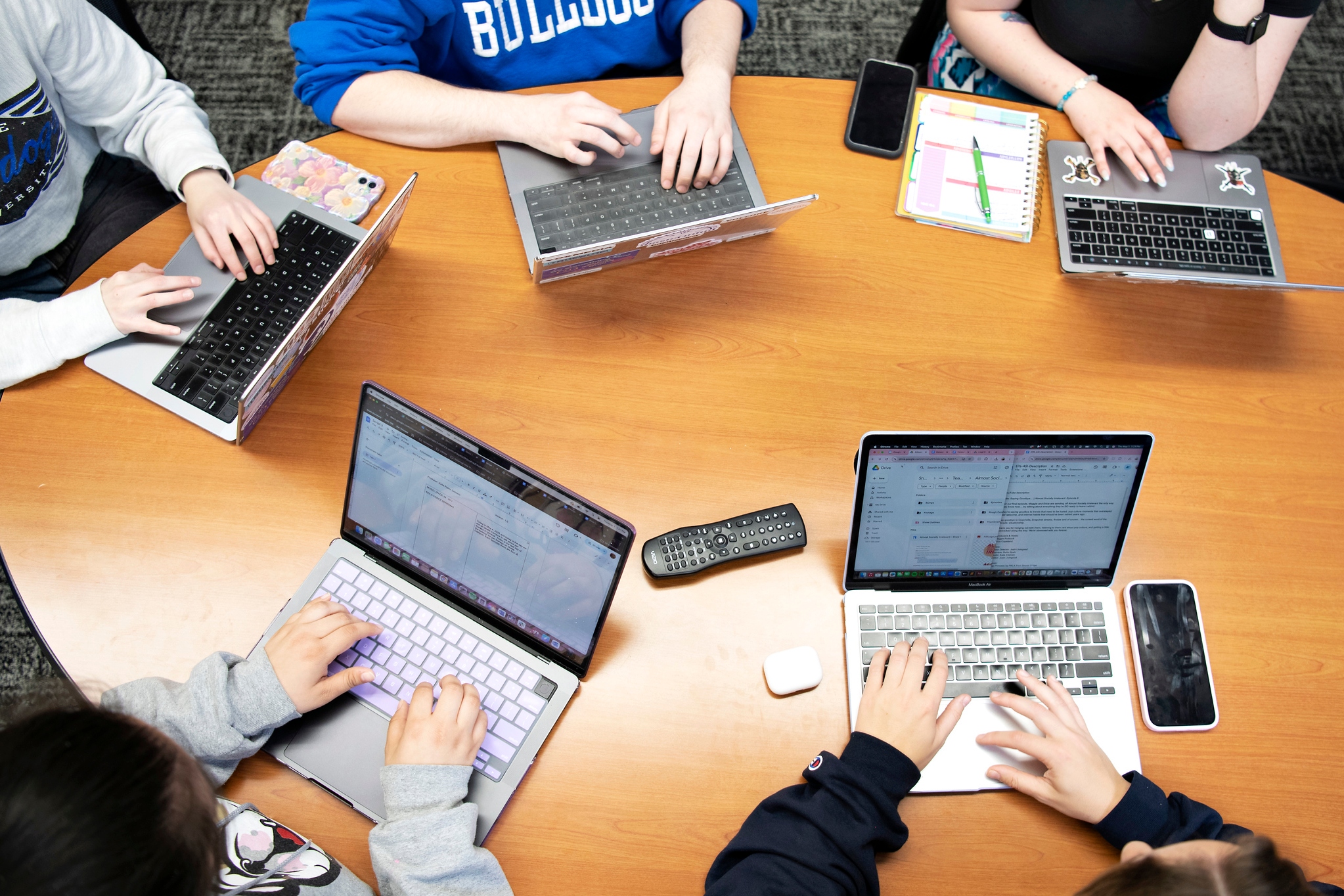Drake Public Relations students use laptops around a table to research internships