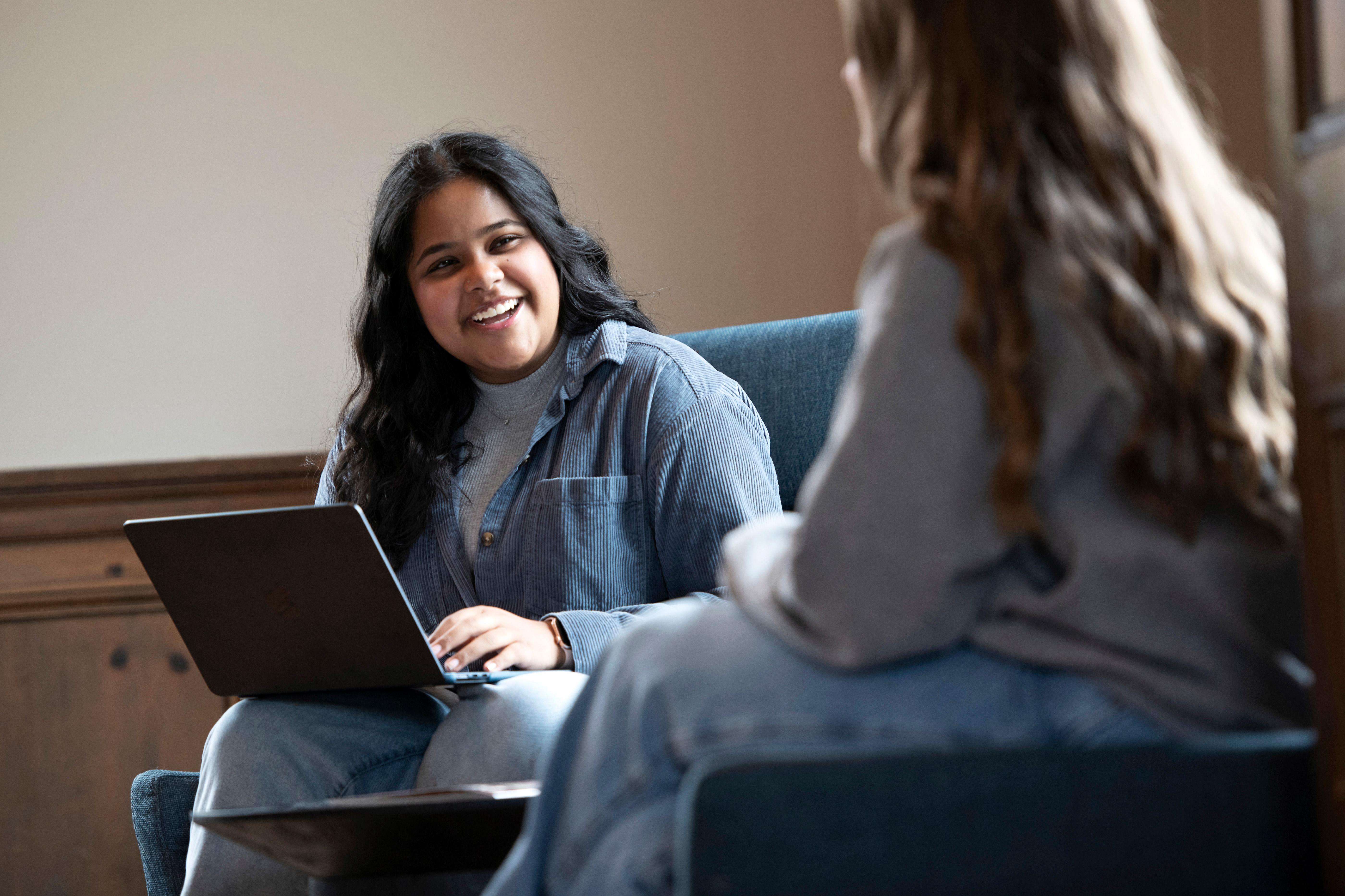 Drake Religious and Interfaith Studies students discuss a project on a couch on a common area