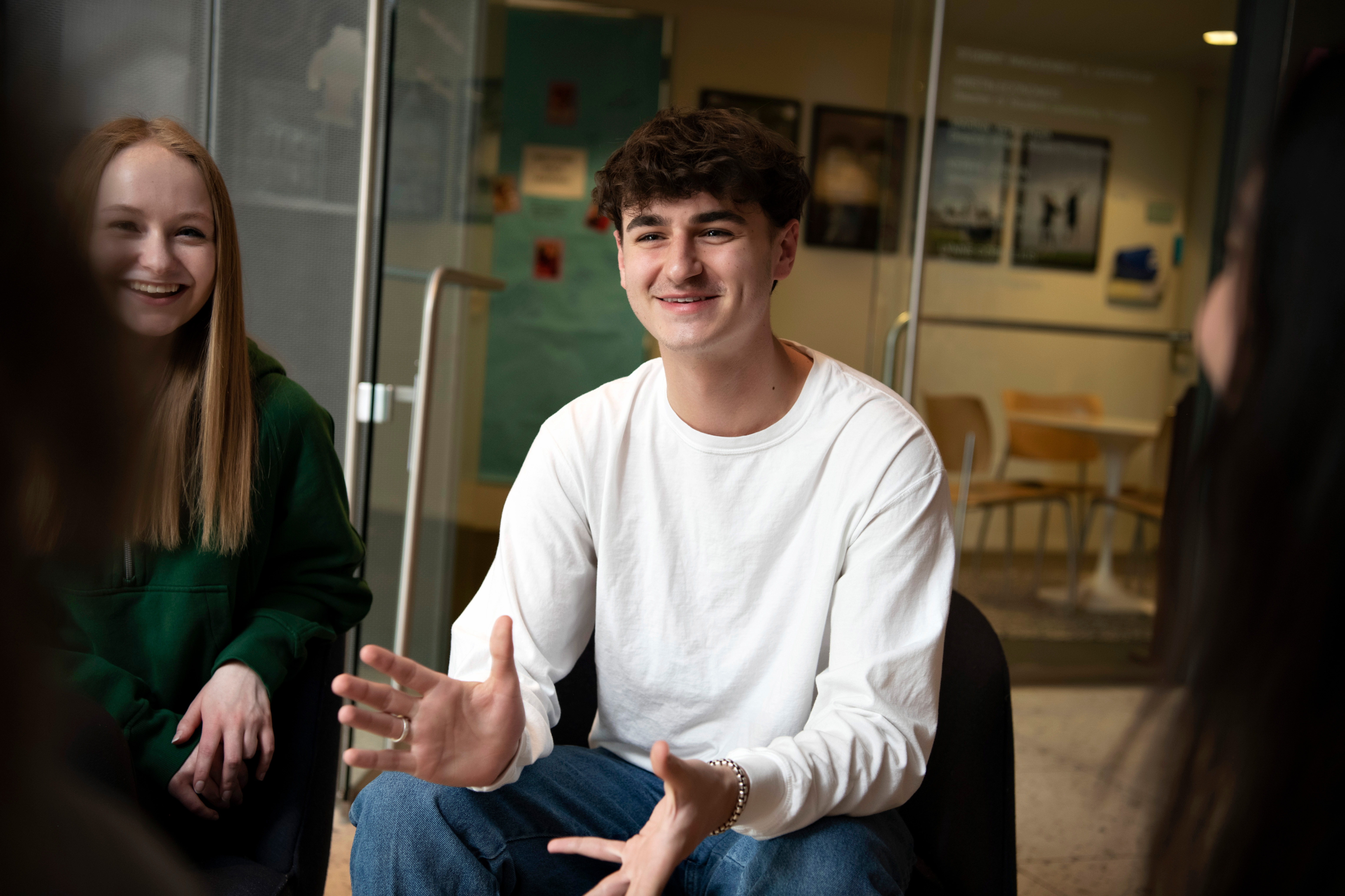 A Drake Religious and Interfaith Studies student gestures with their hands while explaining an idea to other students sitting in a circle