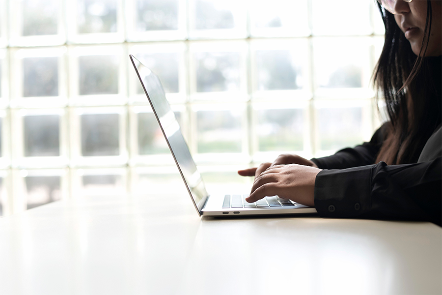 A Drake Risk Management and Insurance student studies for their CPCU exams, using a laptop