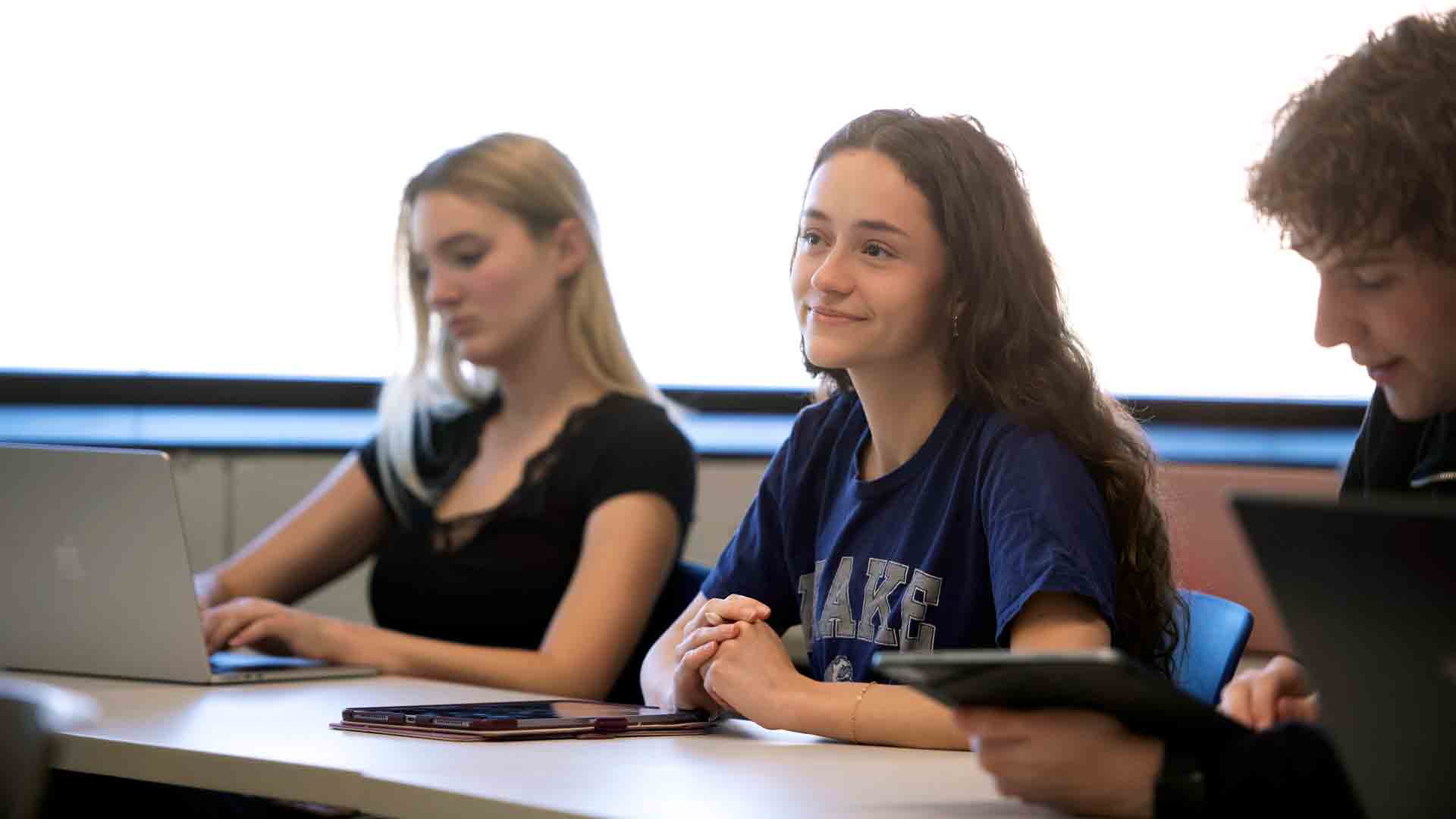 Drake Spanish Majors intently listen or type during a lecture in a bright-lit classroom
