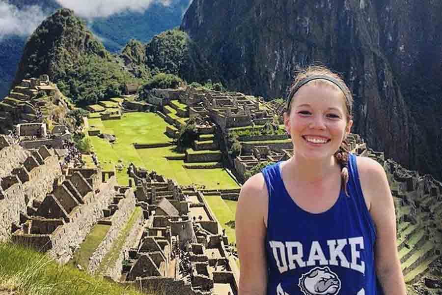 A Drake Spanish Major smiles in front of Machu Picchu during a study abroad trip