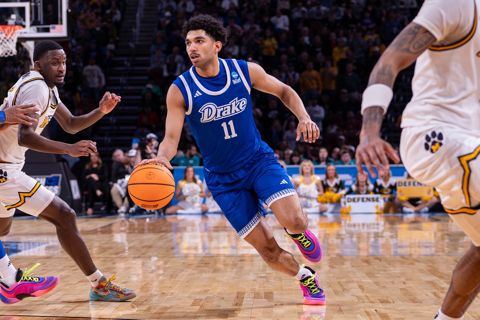 A student from Drake's NCAA Division I basketball team dribbles a ball on the court during a game