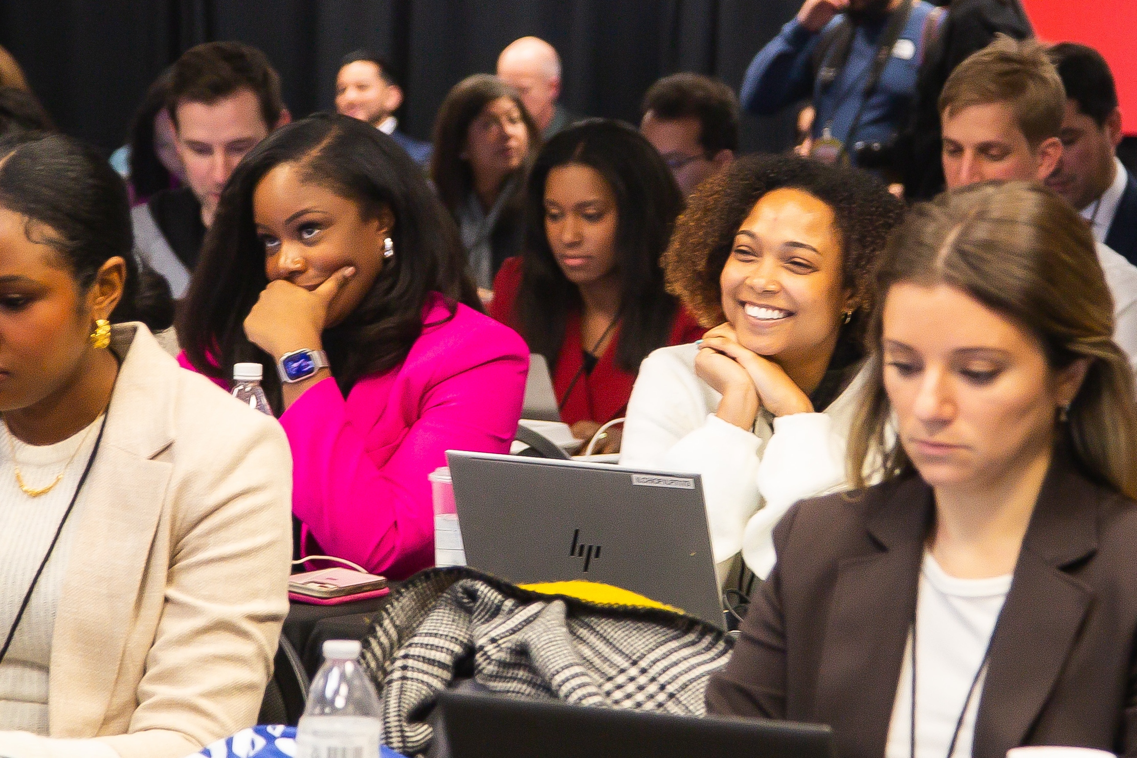 Students from Drake's Strategic Political Communication Major take notes on laptops while watching a debate from the audience