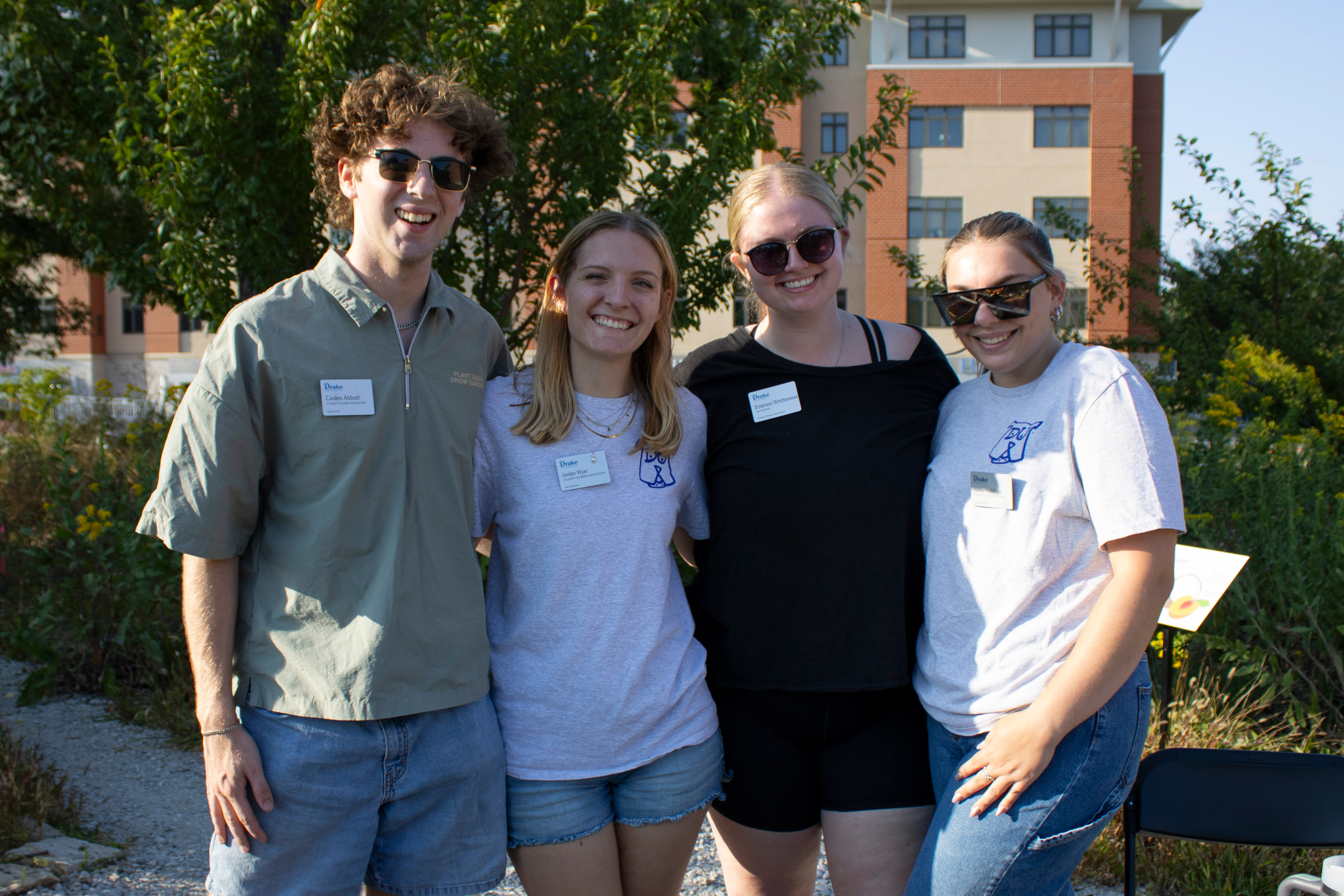 Four students stand together smiling at the camera