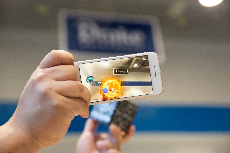 A student uses their smart phone as an augmented reality device