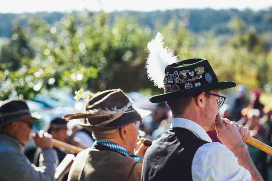 A group of individuals playing traditional German instruments while wearing traditional German outfits