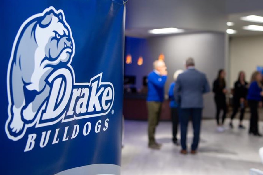 a Drake Athletics banner in focus with blurred people in the background on the right