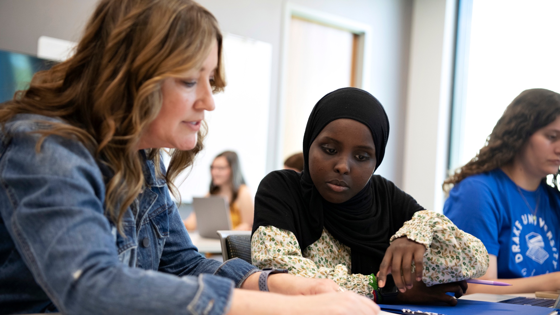 Tonia Land working with a student wearing a hijab