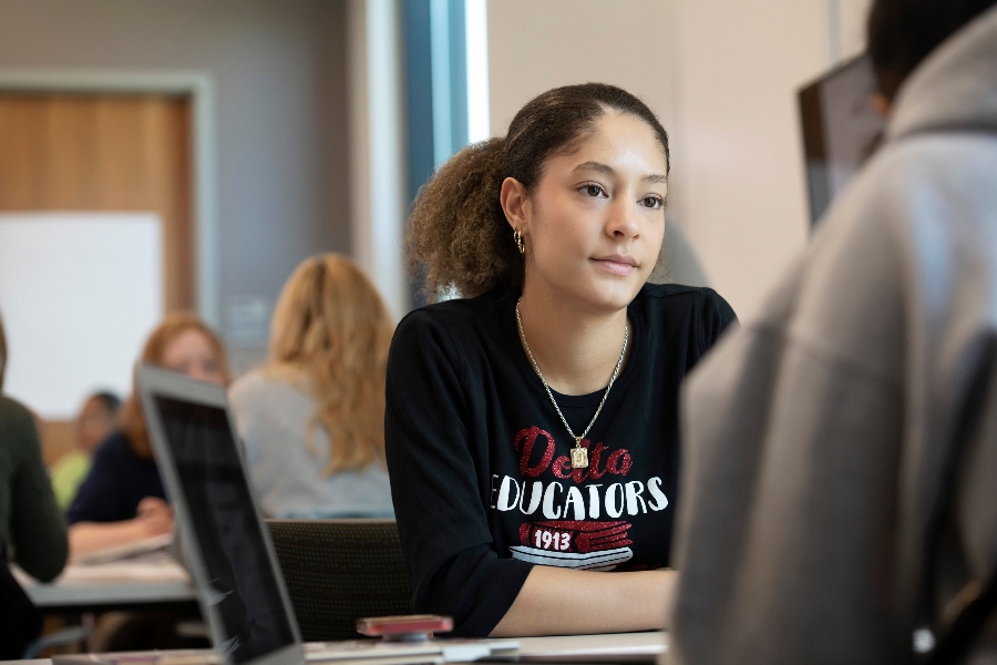 A student intently listening to her deskmate