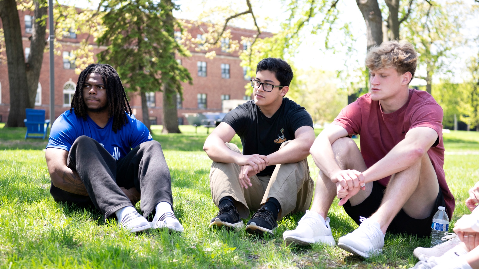Three students sitting outside doing class group work