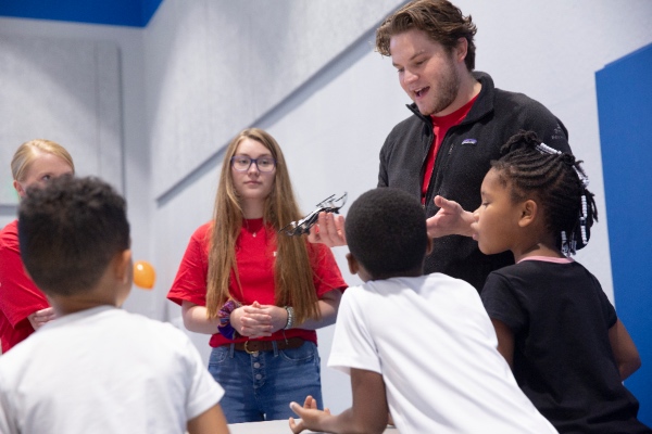 Students teaching young community members about drones