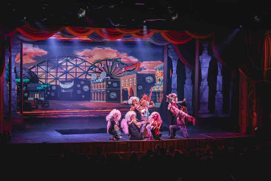 A group of students on stage in costume during a theatre production