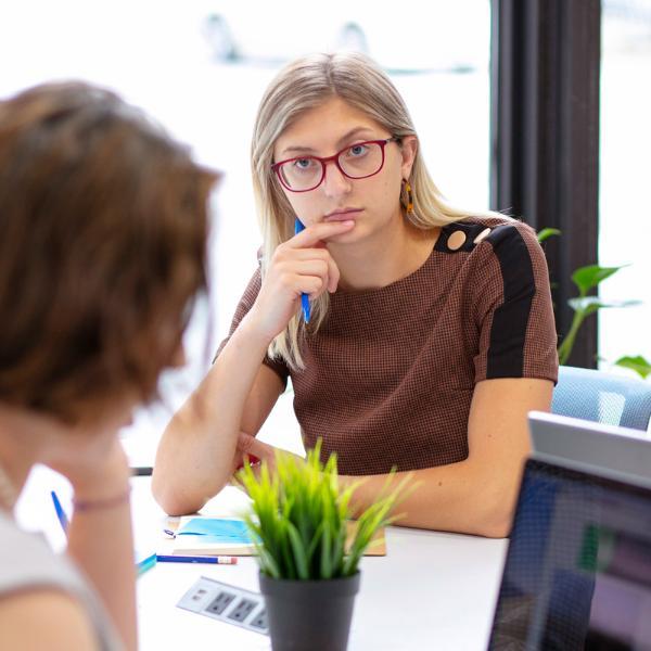 Two Drake University students working together sitting across from each other at a table indoors