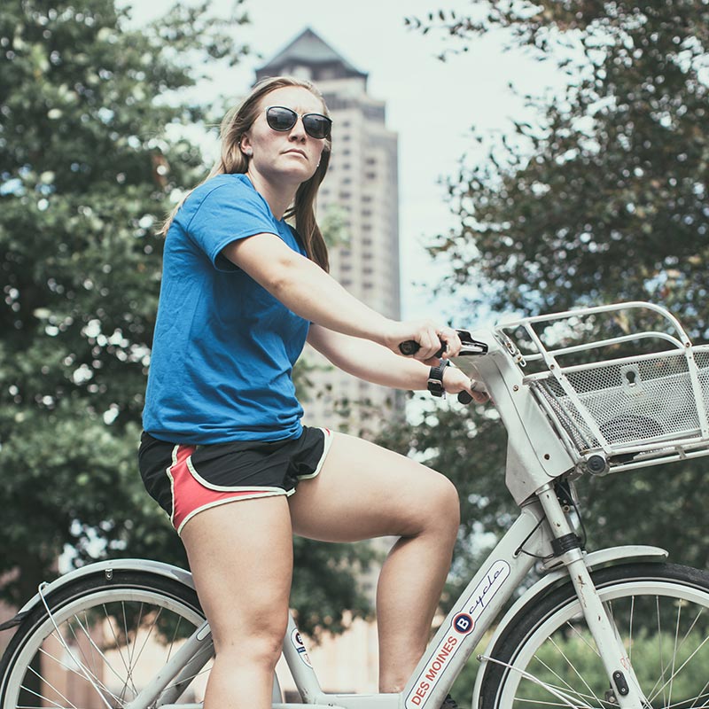 Drake student riding a BCycle in downtown Des Moines
