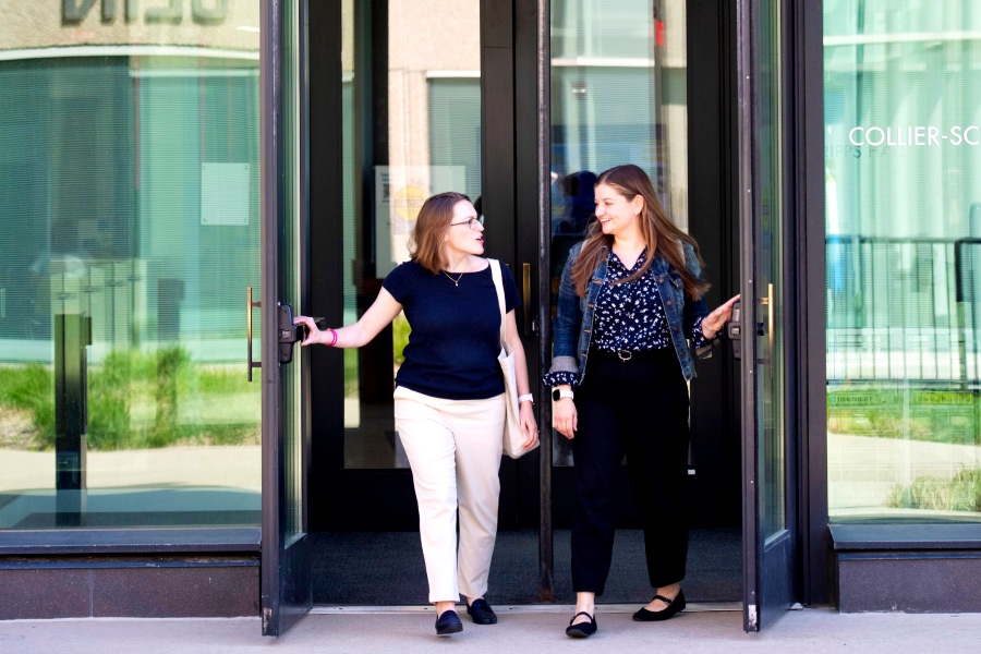 two students walking and talking as they exist the soe